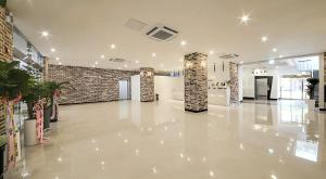una grande hall con pavimenti bianchi e un muro di mattoni di Mokpo Ayana Hotel & Poolvilla a Mokpo