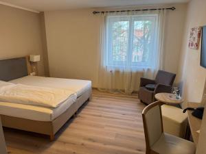 a bedroom with a bed and a chair and a window at Hotel Central in Zeven +44 photos