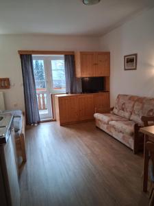 a living room with a couch and a television at Penzion Zákoutí Deštné v Orlických horách in Deštné v Orlických horách