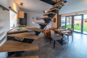a living room with a spiral staircase and a table and chairs at L'école Buissonnière - Suite Bien-être 2 personnes in Vielsalm