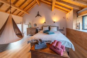 a bedroom with a large bed and a hammock at L'école Buissonnière - Suite Bien-être 2 personnes in Vielsalm