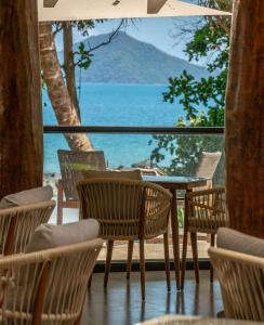 Nala Resort في ميشن بيتش: طاولة وكراسي مطلة على المحيط
