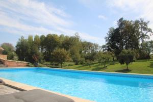 ein großes Schwimmbad in einem Hof mit Bäumen in der Unterkunft A L'Esquirot in Gabarret