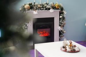 a living room with a fireplace with a christmas tree at Caprioara Spa&Wellness Resort in Covasna +124 photos