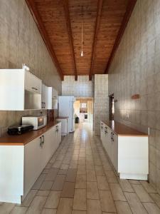 a large kitchen with white appliances and a wooden ceiling at Spacious 7 bedroom house with pool and jacuzzi in Johannesburg