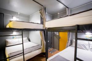 a group of three bunk beds in a room at Beehive Phuket Old Town Hostel in Phuket +35 photos