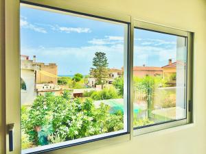 een raam met uitzicht op een tuin bij Blu Mare Casa Vacanza in La Maddalena