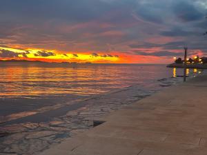 a sunset over a body of water with a sidewalk at Villa Nico in Zadar