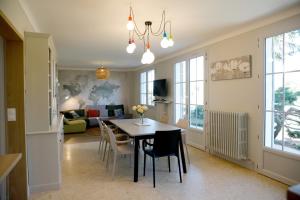 a dining room and living room with a table and chairs at LE CEDRE Maison bord de LOIRE 4 in Muides-sur-Loire