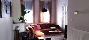a living room with a brown couch with pink pillows at Wervik-94 in Wervik +6 photos