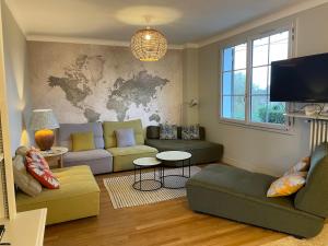 a living room with couches and a map on the wall at LE CEDRE Maison bord de LOIRE 4 in Muides-sur-Loire