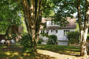 a white house with trees in front of it at LE CEDRE Maison bord de LOIRE 4 in Muides-sur-Loire