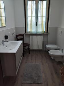 a bathroom with two sinks and a toilet and a window at Malpensa monolocale indipendente in Samarate