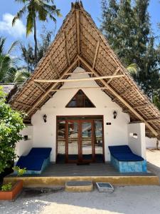 米查维Sunset Mkuu Boutique Hotel的白色的小建筑,有大屋顶