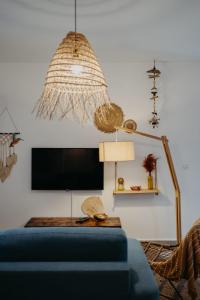 a living room with a blue couch and a tv at Les Villas Mandju in Sainte-Rose