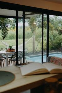 an open book on a table with a view of a pool at Les Villas Mandju in Sainte-Rose