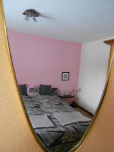a reflection of a bedroom with a bed in a mirror at B&B Zur Tanne in Bad Dürrheim +3 photos