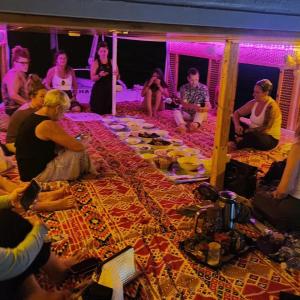 阿斯旺Rayan Nubian Guest House的一群人围坐在桌旁吃饭