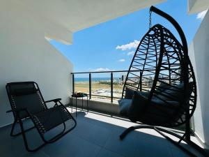 a room with a swing and two chairs on a balcony at Seaview stylish one bedroom apartment in Caesar Romulus 88 in Bahçeler
