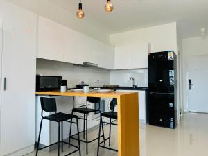 a kitchen with a counter with stools and a black refrigerator at Seaview stylish one bedroom apartment in Caesar Romulus 88 in Bahçeler