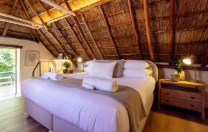 una camera da letto con un letto grande con lenzuola bianche di Weltevreden Estate a Stellenbosch Altre 119 foto