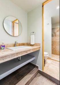 a bathroom with a sink and a toilet and a mirror at Kamya cottage in New Delhi