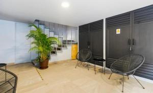a room with chairs and a plant in a building at Kamya cottage in New Delhi