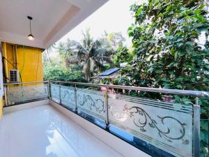 ein Balkon mit einem weißen Geländer und einem Baum in der Unterkunft Villa platinum 4 BHK Calangute in Calangute