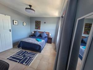 een slaapkamer met een bed met blauwe lakens en blauwe kussens bij Amanzi 1305 in Vosburg +16 foto's