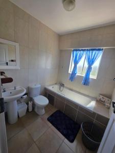 een badkamer met een bad, een toilet en een wastafel bij Amanzi 1305 in Vosburg