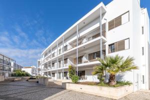 an apartment building with a palm tree in the courtyard at Apartment Atlantico, Town Centre in Tavira