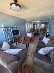 een woonkamer met twee banken en een tv bij Amanzi 1305 in Vosburg