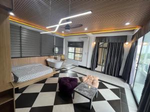 Tây NinhRooftop villa hien dai 2 người的浴室铺着方格地板，里面有一张床和一个浴缸。