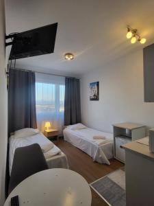 ein Hotelzimmer mit zwei Betten und einem Tisch in der Unterkunft VESTA Apartamenty P23 in Stettin