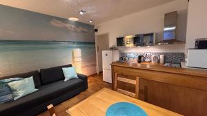 een woonkamer met een bank en een keuken bij Tokelau - Vue Mer in Sausset-les-Pins