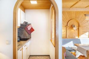 a kitchen and dining room with an arched doorway at Landhaus Perktold in Nesselwängle +142 photos