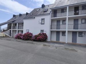 a row of white apartment buildings with purple flowers at Appartement cosy à Damgan avec vue mer 32 m² in Damgan
