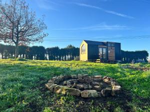 a tiny house in a field with a fire pit at Quinta da Runa by Tiny Away in Bagunte