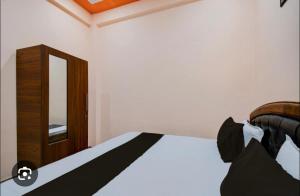 ein Schlafzimmer mit einem Bett mit Spiegel und einer Kommode in der Unterkunft Shree mangalam lnn in Prayagraj