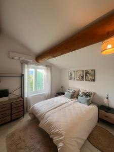 a bedroom with a large white bed and a window at La Parenthèse Balnéo in Donzère +5 photos