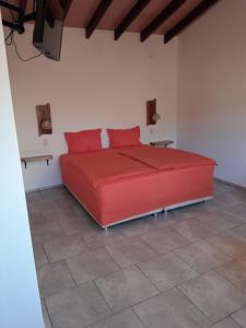 a red bed with red pillows in a room at Casa Stiller in Itá +18 photos