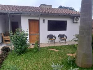 una casa blanca con 2 sillas en el patio en Casa Stiller, en Itá