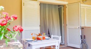 a table in a room with a white table and flowers at Green Garden Village in Sirolo