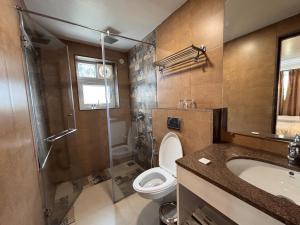 a bathroom with a toilet and a shower and a sink at The Tanisi Resorts & Pool Villas, Candolim in Candolim