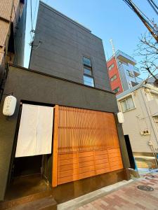 a building with a large wooden garage door at NEW Hotel Komugi Skytree - modern Japanese-style guesthouse near Asakusa & Skytree 3mins, whole house rental perfect for large groups up to 14pax in Tokyo