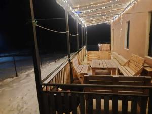 un balcone con panchine di legno e luci su un edificio di Tsemi Guesthouse of the Mountains a Tba