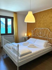 a bedroom with a white bed with a lamp at Serena Charme Green Holiday in Ledro