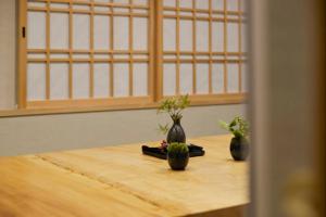 two vases sitting on a table with plants in them at NEW Hotel Komugi Skytree - modern Japanese-style guesthouse near Asakusa & Skytree 3mins, whole house rental perfect for large groups up to 14pax in Tokyo