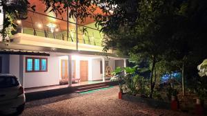 een huis met een auto ervoor geparkeerd bij Hestia Homestay in Kottayam