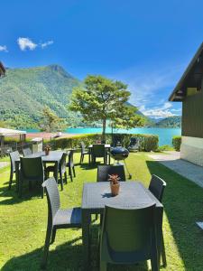 a patio with tables and chairs and a lake at Serena Charme Green Holiday in Ledro